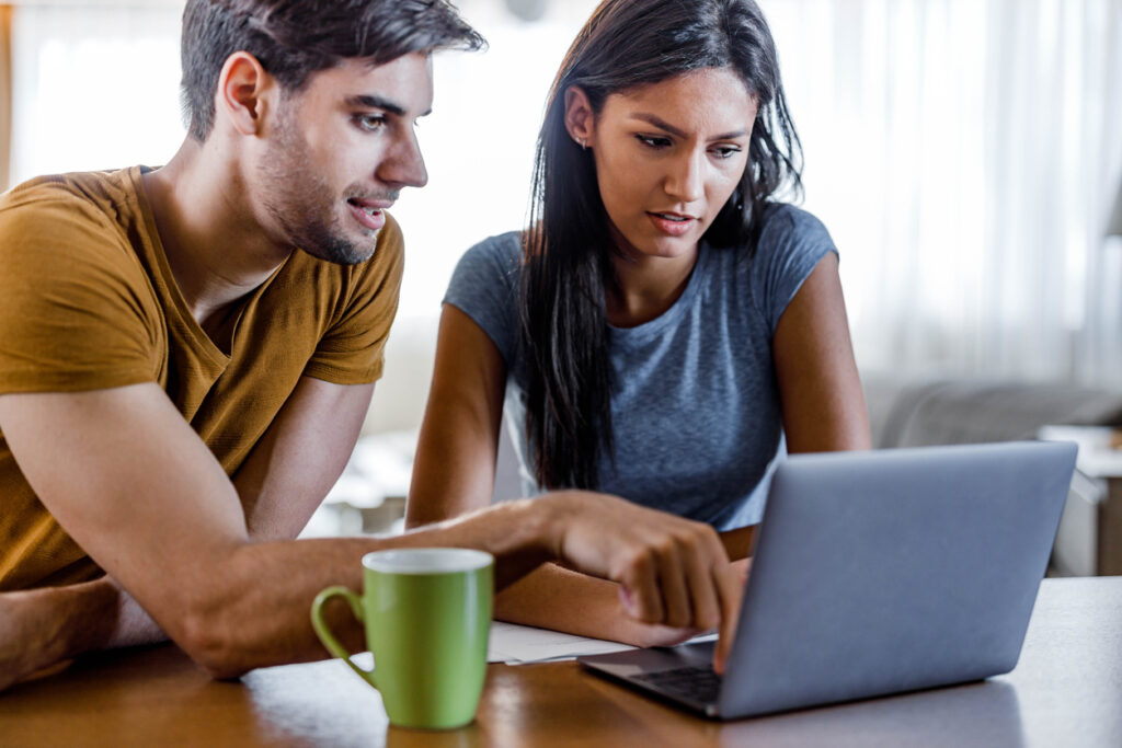 Young Couple Using Laptop At Home.