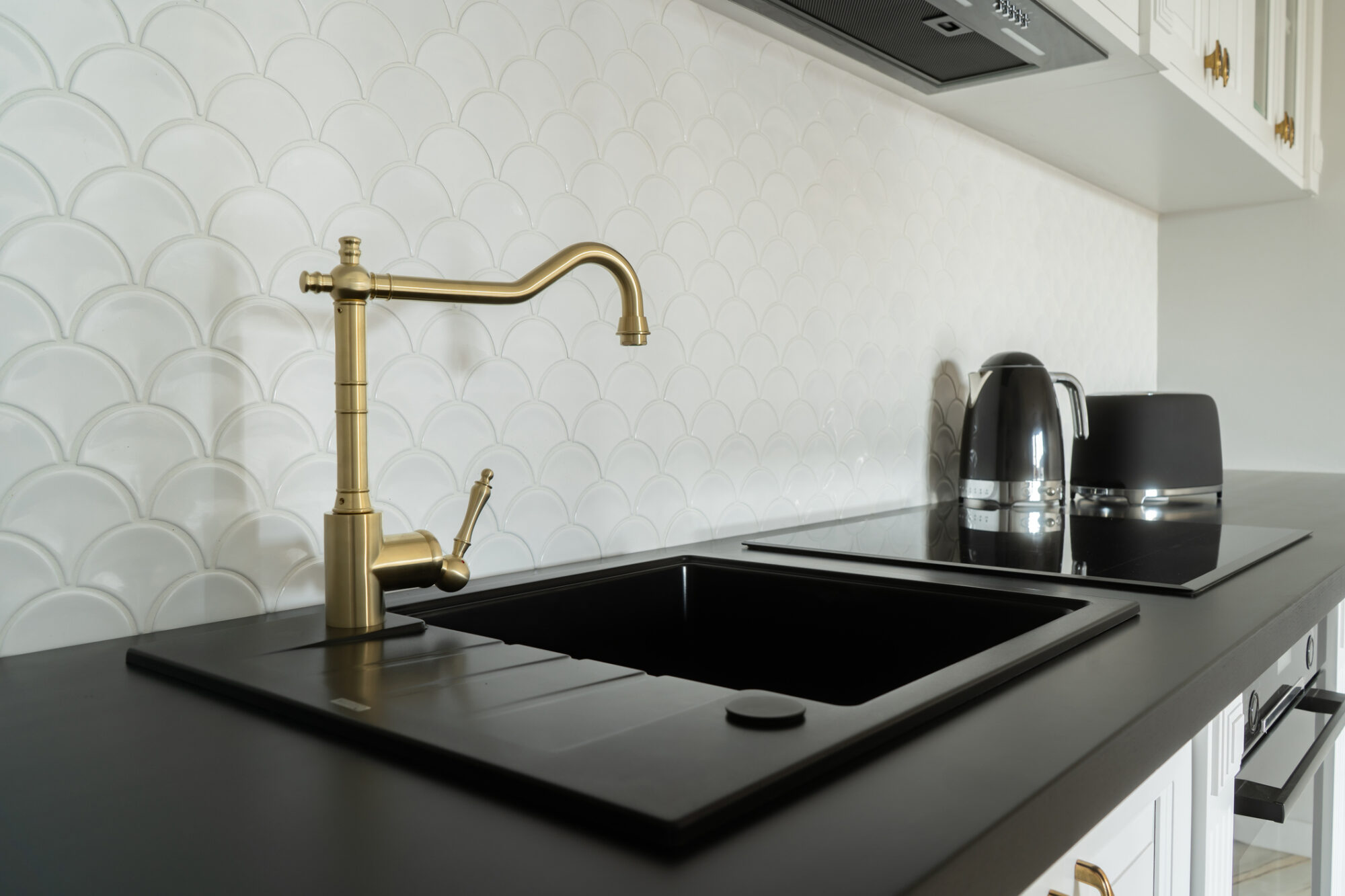 Stylish Kitchen Sink With Gold Faucet And Black Countertop