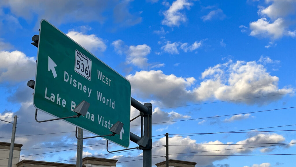 Road sign pointing to Disney World and Lake Buena Vista in Orlando, Florida